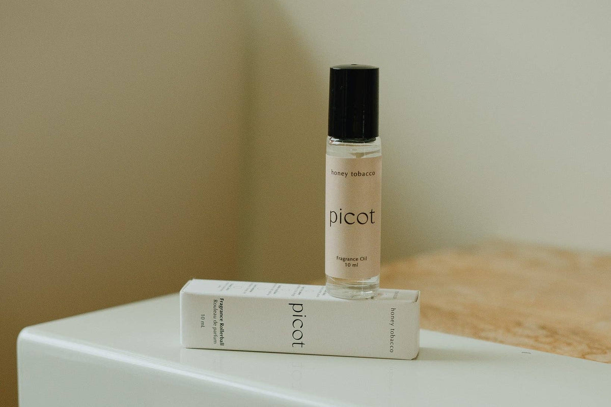 Picot Honey Tobacco fragrance rollerball and packaging on a white surface with a neutral background