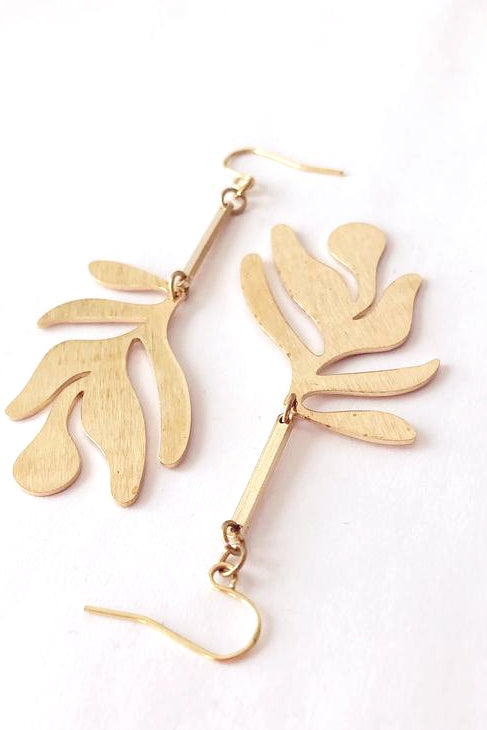 Fullie dangle earrings by Darlings of Denmark; brushed texture raw brass; abstract leaf hanging off slim brass bars; flat lay