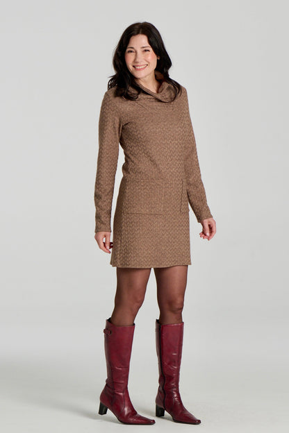 A woman wearing the Sacha Tunic by Kollontai in Brown, a textured knit straight cut tunic with a funnel collar and large patch pockets. She is standing in front fo a white background. 