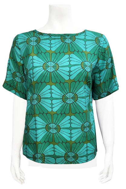 The Cecil Box Blouse by Mandala in Vintage Tile print is shown on a mannequin against a white background. It has a high neckline, wide 1/2 sleeves, and a side hem slit detail. 