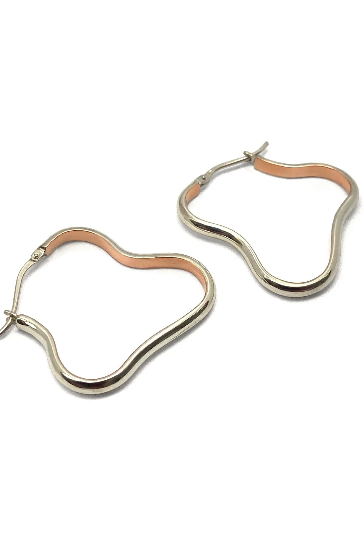 Pair of hoop earrings with cooper and silver finish on a white background