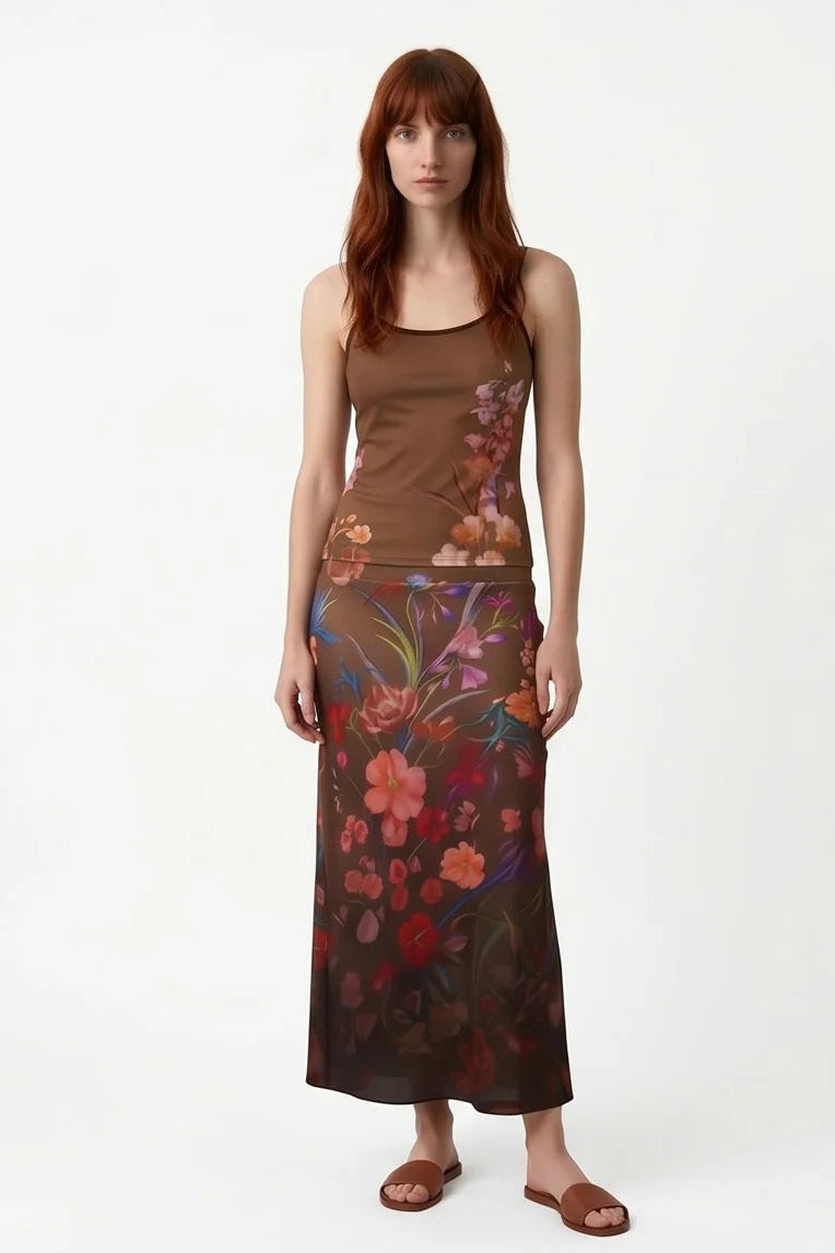 A woman wearing the Charlotte SKirt by Kollontai, a long slim cut brown skirt adorned with a floral pattern. She is wearing it the matching Morganne Top against a white background
