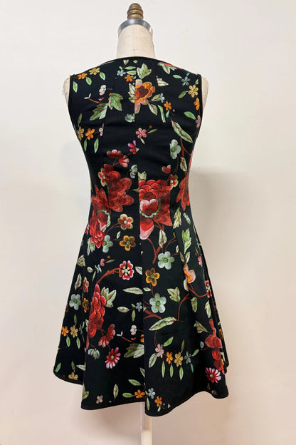 Back view of the Silba Dress FW26/27 by Kollontai in Black Floral, a short sleeveless dress with princess seams and an above the knee skirt, is shown on a mannequin against a white background. 