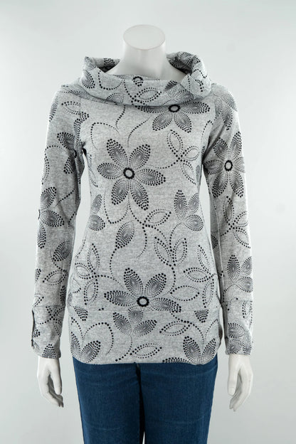 The Teddy Pearl Sweater by Karkass in Grey and Black, a cowl neck sweater with a floral pattern in black dots, is shown on a mannequin with jeans against a white background. 