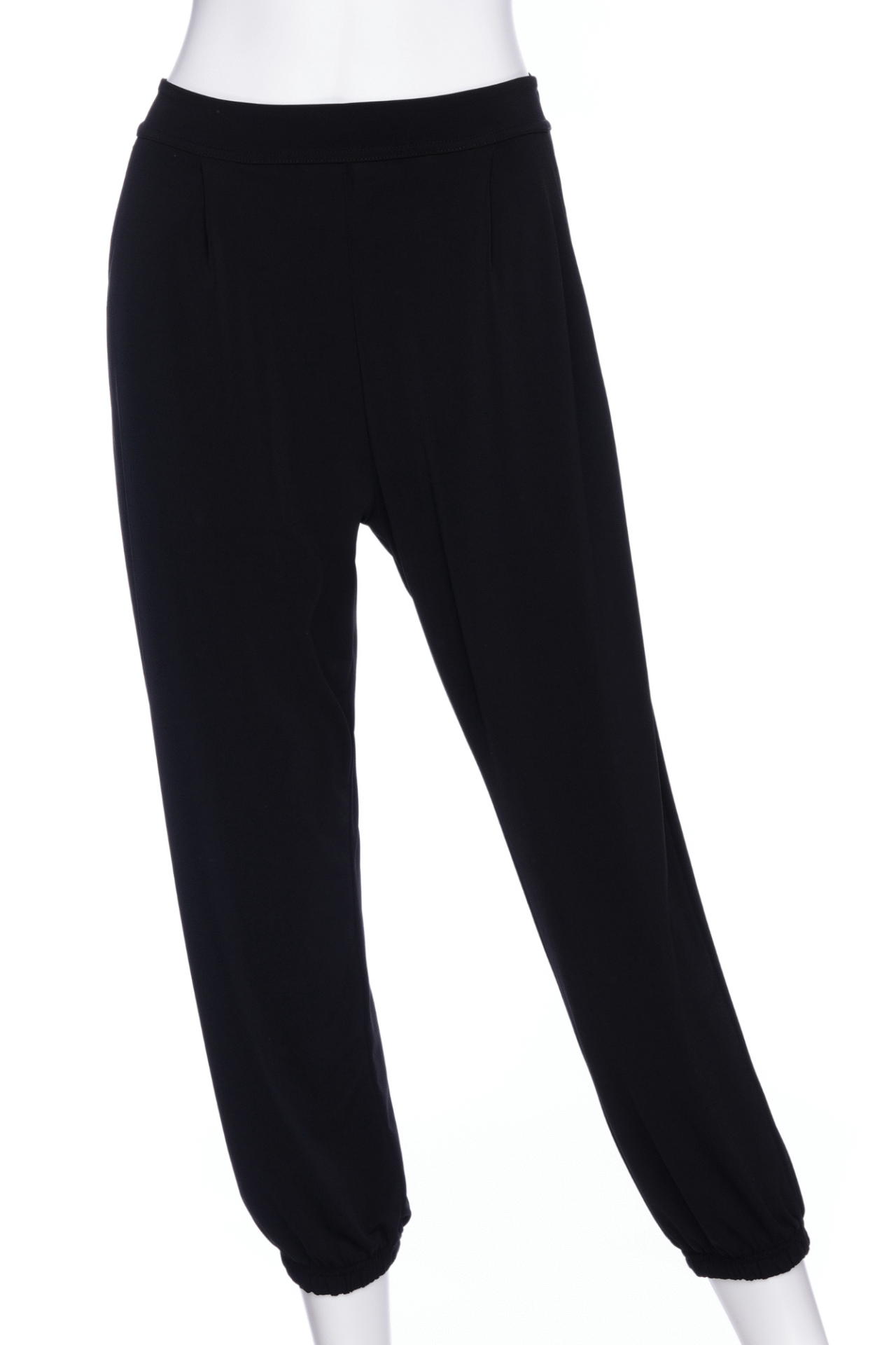 The Pina 7/8 Pants by Rien ne se Perd in Black, with a pull on waist, front pleats, cuffed legs, and a pockets, are shown on a mannequin in front of a white background. 