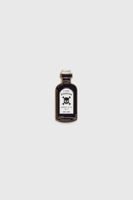 The Poison Pin by Badaboöm Studio, featuring a tiny bottle of poison, is shown against a white background. 