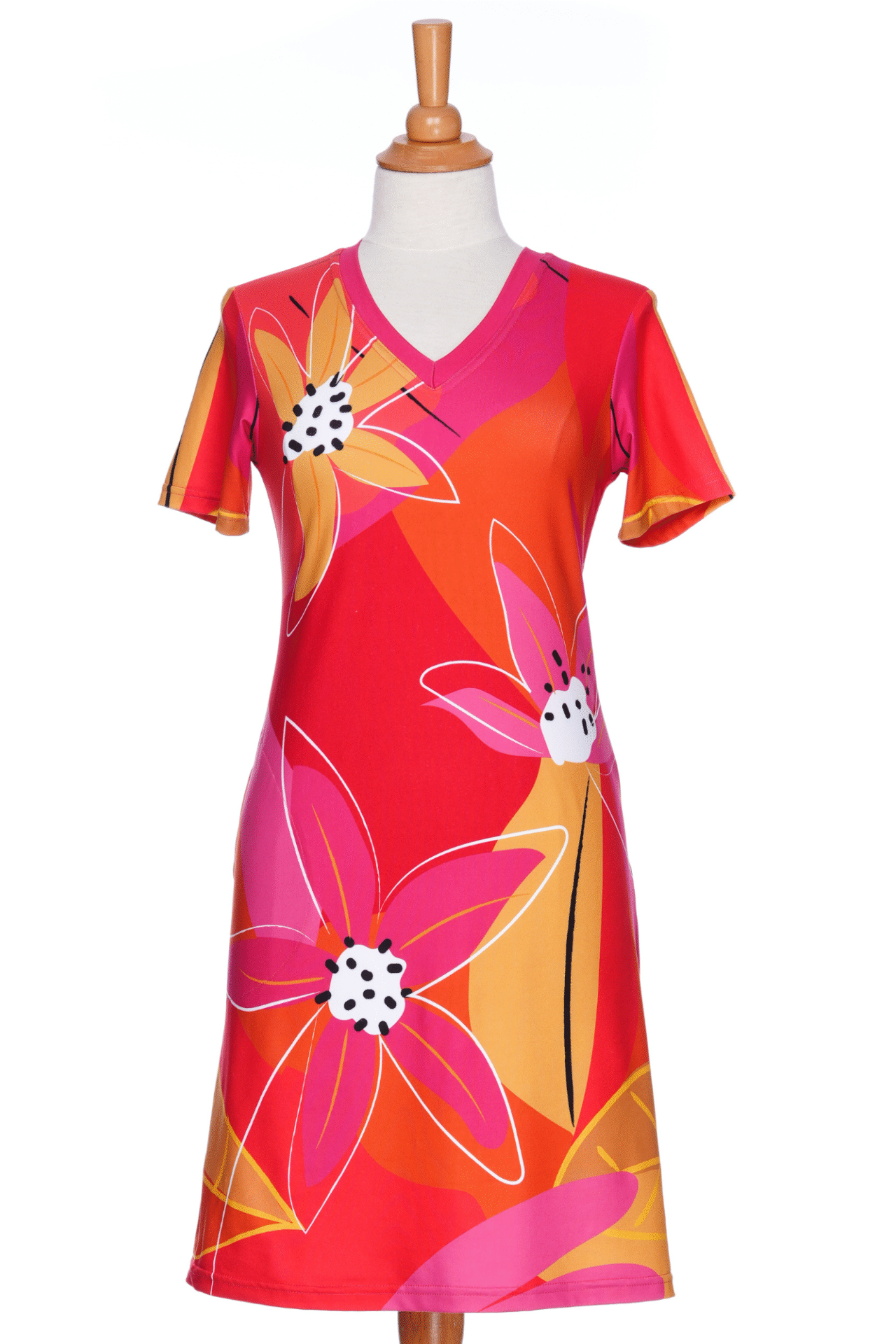 The Aperol Dress from Rien ne se Perd, a short flared dress with a V-neck, short sleeves, and a colourful Pink floral pattern, is shown on a mannequin in front of a white background. 