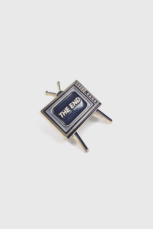 Badaboöm Studio's retro television-shaped enamel pin with 'THE END' lettering on the screen, set against a plain light grey background.